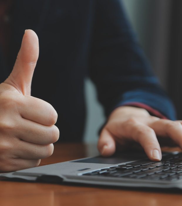 Asian Businesswoman Using laptop computer and working at office with calculator document on desk, doing planning analyzing the financial report, business plan investment, finance analysis concept.